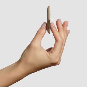 A hand holding the CeQur Simplicity wearable insulin patch showing it's thin and discreet